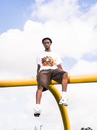 a man is sitting on a yellow railing